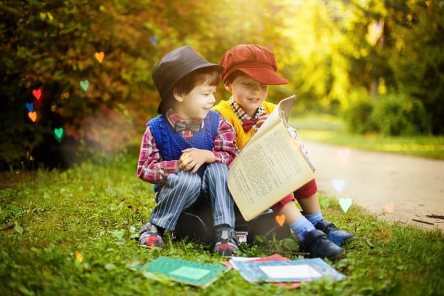 Two children in a field reading